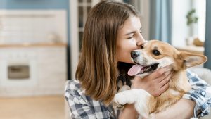 side-view-woman-holding-kissing-her-dog